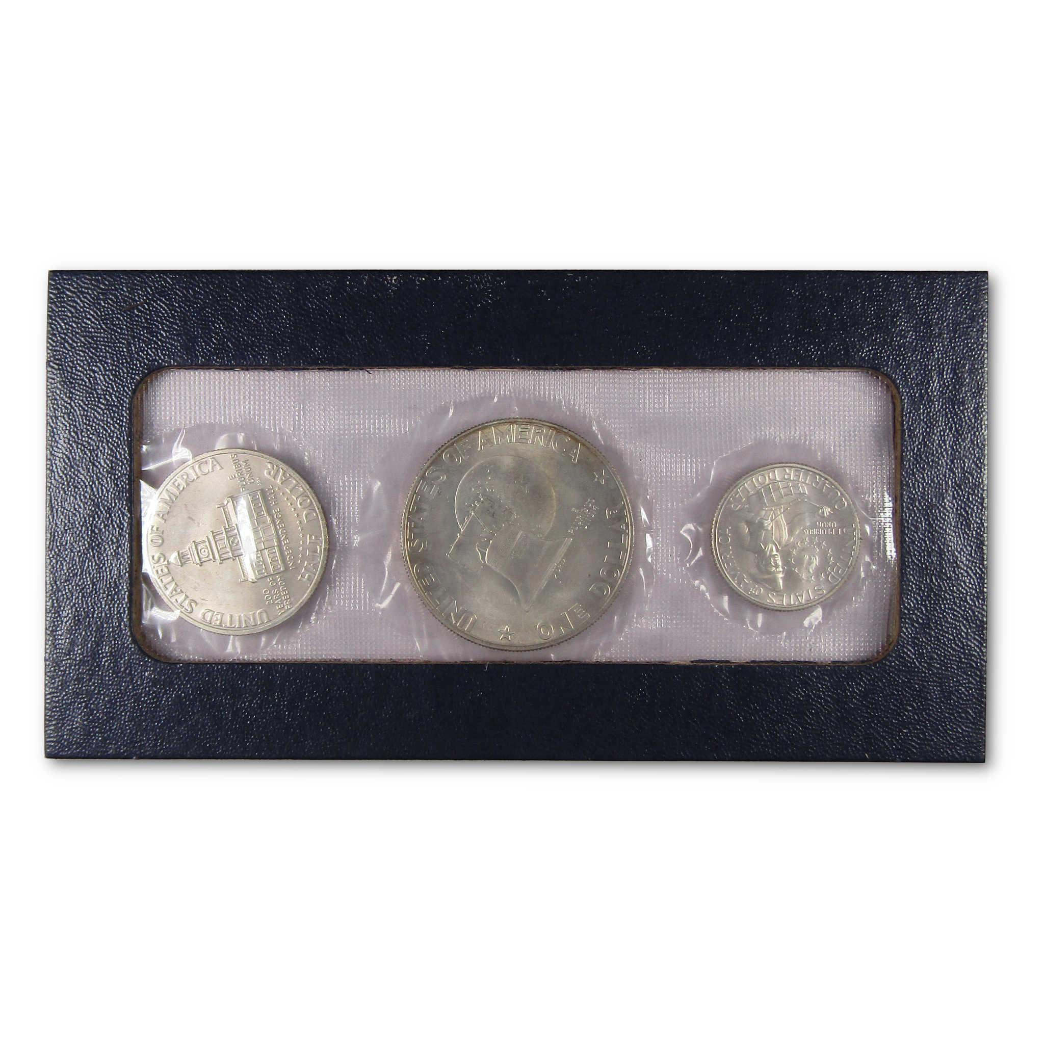 Three collectible US coins in a protective display case on white background